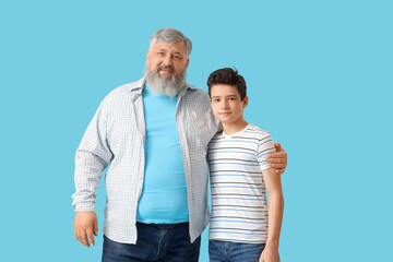 Poster - Happy grandfather with his cute grandson on blue background