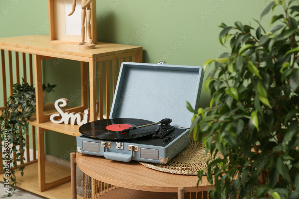 Record player with disk and home decor on coffee table in room