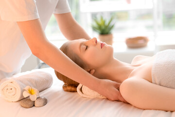 Poster - Young woman enjoying facial massage with essential oil in spa salon