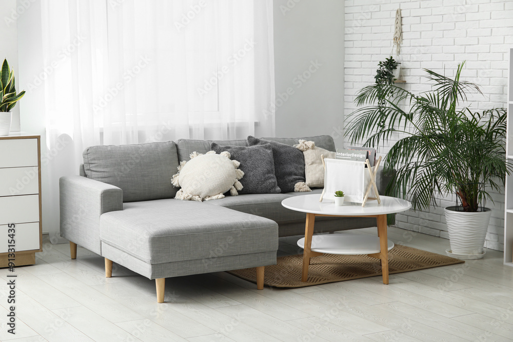 Stylish living room with grey sofa, soft pillows and coffee table