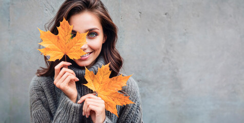 a woman smiles in autumn leaves.