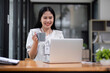 © wichayada - Female Accountant Working on Financial Documents at Desk in Modern Office Environment