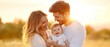 © TEERAWAT - A joyful family moment captured in the golden light of sunset, showcasing love and happiness among parents and their baby.