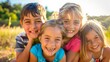© improvee design - Four kids smiling and laughing together outdoors in a field.