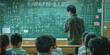 © Aigo labs - A young teacher stands in front of a chalkboard in a classroom, addressing a group of students who are seated at desks facing the board.