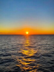 Wall Mural - A sunset over the ocean with the sun setting in the distance