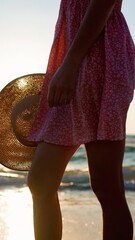 Wall Mural - vertical shot. Happy girl in a dress and hat enjoying her summer vacation on the beach. girl walks along the beach at sunset.