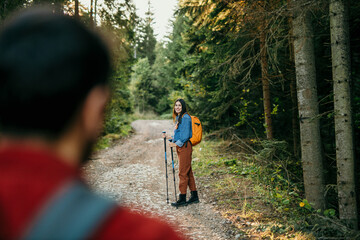 Wall Mural - Two young people are out for an early morning hike. Focus on a woman