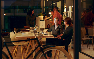 Canvas Print - Night, computer and employee with mentor at desk for collaboration, feedback or project review. Advice, help and business women in discussion for learning, planning report or support in office