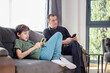 © Cavan - father and son on devices on the couch