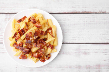 Wall Mural - Delicious French fries with bacon on wooden rustic table, top view. Space for text