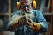 © AspctStyle - Focused carpenter clapping hands to remove sawdust, wearing protective gloves and earmuffs, working in a dusty workshop