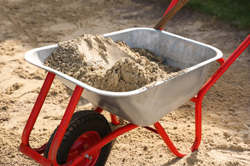 Wall Mural - Metal wheelbarrow with pile of sand outdoors