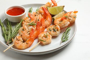 Skewers with delicious grilled shrimps served on white table, closeup