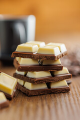 Poster - White light dark chocolate bars on wooden table.