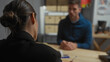 © Krakenimages.com - Woman investigator questions a man in an indoor police interrogation setting, suggesting a crime investigation scenario.