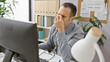 © Krakenimages.com - Stressed man rubbing eyes in office with computer, monitor, desk, plant, lamp, glasses, and shelf
