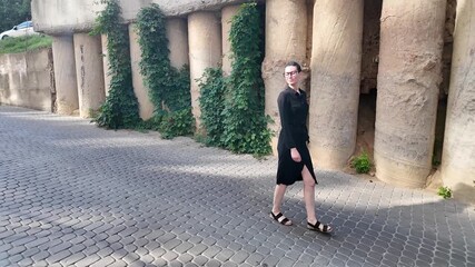 Wall Mural - Woman walking in the city wearing elegant black dress