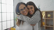 © Krakenimages.com - A smiling mother and daughter embrace lovingly in a cozy, well-lit living room, expressing family warmth and affection.