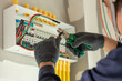 © tong2530 - An electrician carefully installs new wiring in a modern home, ensuring safety and efficiency.