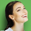 © vgstudio - Portrait of happy excited smiling beautiful young woman with open mouth, looking side away up, isolated over against green background. Brunette laughing girl at studio image. Square composition.