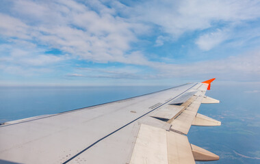 Wall Mural - View from the airplane window at a beautiful cloudy sky and the airplane wing