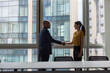 © ReeldealHD images - Business persons handshake in a modern office with views of buildings