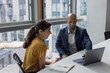© ReeldealHD images - Business colleagues looking at a laptop in an office meeting