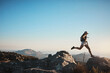 © ReeseBuyout1/peopleimages.com - Hiking, woman and jump on rocks for fitness, wellness and energy at sky mockup. Trekking, female athlete and confident on mountain with gap, travel or adventure in nature space for exercise or growth