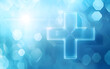 © sornram - A bright blue background featuring a translucent plus sign, ideal for medical or positive health themes.
