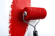 © sornram - A vibrant red paint roller applying a fresh coat of paint to a white wall, showcasing creativity and home improvement.