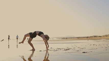 Wall Mural - A woman doing flexibility martial arts on the beach