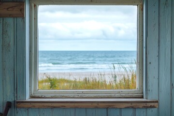 Wall Mural - A window in a small coastal cottage, overlooking a serene beach with gentle waves.