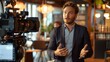 © MIKHAIL - Confident young businessman being interviewed on camera in modern office, gesturing passionately, showcasing communication skills and leadership