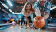 © SERHII - Excited couple enjoying bowling game with orange ball on lane under colorful lights. Concepts of leisure, recreation, and fun activities.