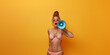 © GraysonStock - A young blonde woman standing with a loudspeaker shouting, isolated from a yellow background, summer advertisement