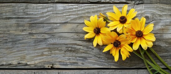 Aufkleber - A lovely yellow flower arrangement sits on a backdrop of wood offering space for text or graphics. Creative banner. Copyspace image