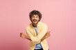 © Maria Vitkovska - Smiling, attractive Indian man with curly hair smiling and posing on pink background