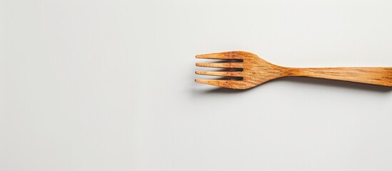 Poster - One wooden fork isolated on a white background is a kitchen utensil for food enthusiasts Ideal as a background wallpaper or copy space image