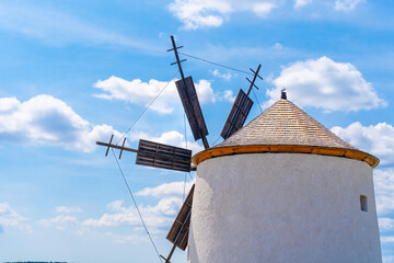 Old traditional windmill with cloudy blue sky in the background