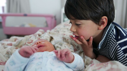 Big brother gently interacting with newborn baby on the bed, expressing curiosity and tenderness, indoor bedroom environment, sibling bonding, loving and protective gestures, family moment