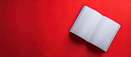 Poster - A flatlay view photo showing an open clear copybook on a red backdrop with ample copy space image