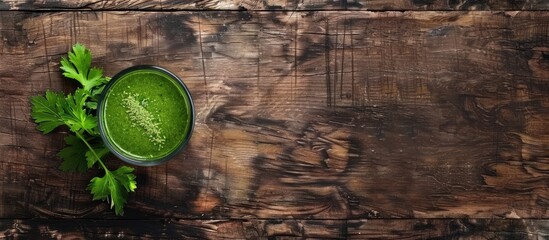 Wall Mural - Vegan vegetable smoothie topped with parsley on a wooden backdrop in banner format featuring copy space image