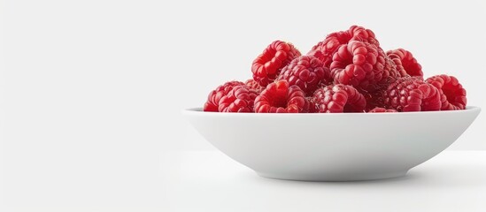 Sticker - A bowl with a fresh ripe raspberry displayed on a white background ideal for a copy space image