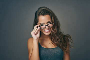 Wall Mural - Woman, portrait and happy with glasses in studio on grey background for prescription, eyewear and eyesight. Female person, smile and satisfied or confident with frame for spectacles, lens and vision