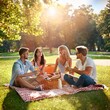 © Vinicius - Young friends having a picnic in the park on a sunny day