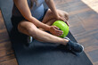 © puhimec - A pregnant woman in the gym sits on a mat with a ball in her hands.
