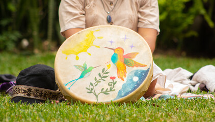 drum painted with watercolors with a woman behind it