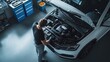 © inthasone - Under the hood. A car mechanic working on the engine of a white car in a modern workshop, car repairs concept, top view.
