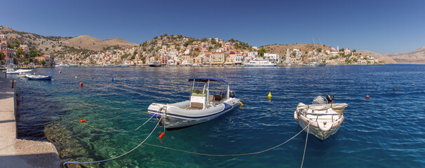 Wall Mural - Bright colorful houses on the shore of the bay in the Greek fishing village Symi